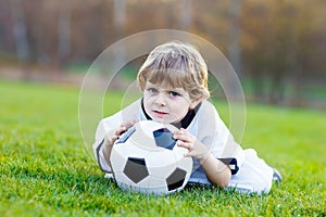 Kid boy playing soccer with football