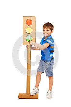 Kid boy pointing to green signal of traffic light