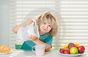 Kid boy pouring whole cows milk. Kid eating healthy food vegetables. Breakfast with milk, fruits and vegetables. Child