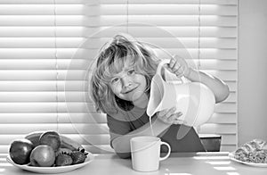 Kid boy pouring whole cows milk. Kid eating healthy food vegetables. Breakfast with milk, fruits and vegetables. Child