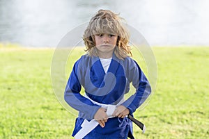 Kid boy practicing karate outdoor. Sport karate kids. Little boy wearing kimono doing karate in park. Little karate