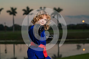 Kid boy practicing karate outdoor. Sport karate kids. Little boy wearing kimono doing karate in park. Little karate