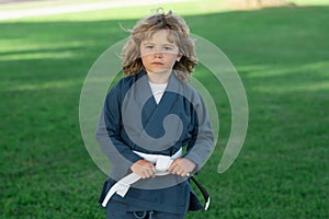 Kid boy practicing karate outdoor. Sport karate kids. Little boy wearing kimono doing karate in park. Little karate