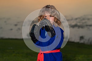 Kid boy practicing martial arts outdoor. Sport martial arts kids. Little boy wearing kimono doing karate in park. Child