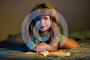 Kid boy reading books. Towards knowledge. Boy with book read story over dark nigh room background. Child enjoy study and