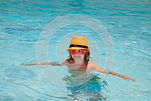 Kid boy relaxing in pool. Child swimming in water pool. Summer kids activity, watersports.