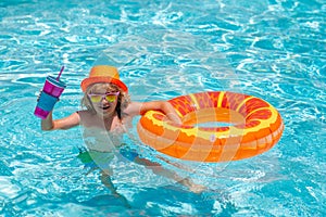 Kid boy relaxing in pool. Child swimming in water pool. Summer kids activity, watersports. Summer kids cocktail.