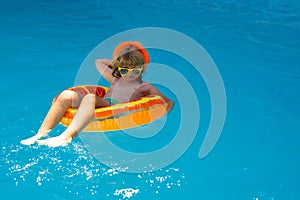 Kid boy relaxing in pool. Child swimming in water pool. Summer kids activity, watersports. Summer vacation with children