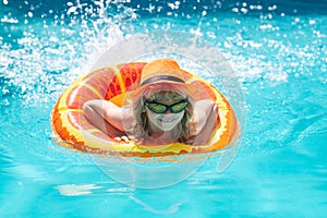Kid boy relaxing in pool. Child swimming in water pool. Summer kids activity, watersports. Summer vacation with children