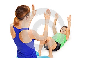 Kid boy repeating physical exercises after trainer