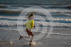 Kid boy running on beach having fun on summer holidays. Happy kids playing on sea. Children in nature with sea. Happy