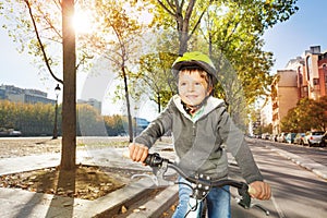 Kid boy in safety helmet riding bike on cycle path