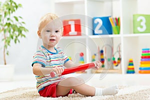 Kid boy sitting with big red pencil