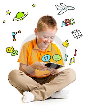 Kid boy sitting with tablet computer and learning or playing