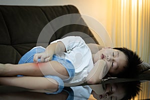 Kid boy is sleeping during the day at home,child using hand to scratch legs,itchy rash,red spot to mosquitoes bites or insect