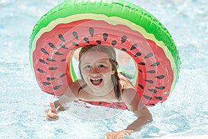 Kid boy splashing in swimming pool having fun, leisure activity. Child swim with float ring on summer vacation holidays.