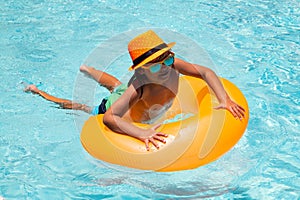 Kid boy splashing in swimming pool. Swim water sport activity on summer vacation with child. Child water toys, floating