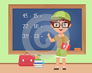 Kid boy student studying math in classroom, standing at blackboard to write exercise