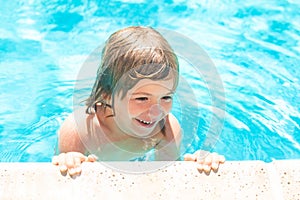 Kid boy swim in swimming pool. Little boy playing in outdoor swimming pool in water on summer vacation. Child learning