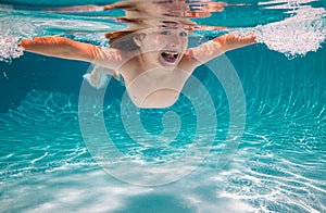 Kid boy swim underwater in pool. Child swimming and diving underwater in water pool. Underwater kids activity