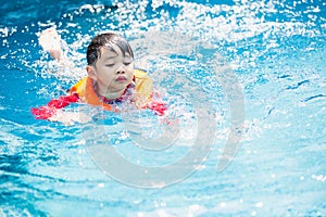 Kid boy swimming pool exercise in holiday activities.