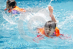 Kid boy swimming pool exercise in holiday activities. swim practice sports