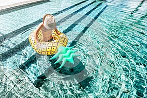 Kid boy in swimming pool on inflatable ring. Children having fun on sunny vacation day, healthy outdoor sport activity for