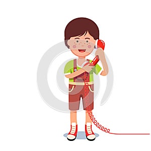 Kid boy talking on a retro wired telephone