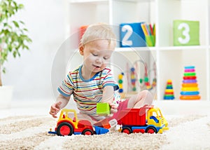 Kid boy toddler playing with toy car
