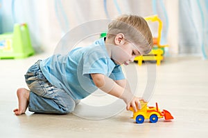 Kid boy toddler playing with toy car