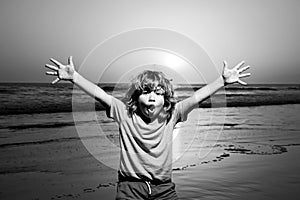 Kid boy walking to beach, raised hands. Amazed surprised kids emotions.