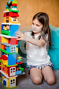 Kid is building a house of blocks, a constructor.