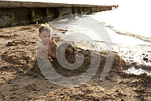 Kid buried in sand on beach