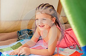 Kid campgound concept. Adorable girl playing in tent. Kids camping. Having fun outdoors. Happy kid in camp on picnic.