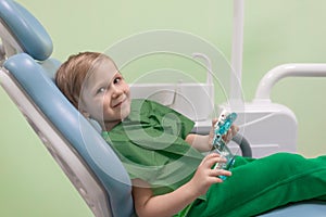Kid caucasian child examine teeth treat in jaw on chair at dentist, close-up. Concept for pediatric dentistry, play and toys in