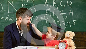 Kid cheerful distracting while studying, attention deficit. Naughty child concept. Father with beard, teacher teaches