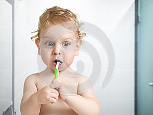 Kid or child brushing teeth in bathroom