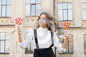 Kid child holding lollipops candy outdoors. Happy kid with candy. School nutrition. Calories and energy. Picking flavour