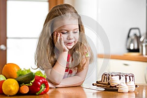 Kid choosing between healthy vegetables and tasty sweets