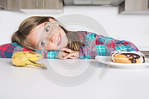 Kid choosing between healthy vegetables and tasty sweets