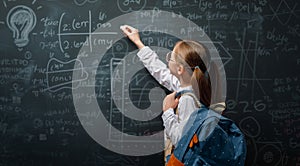 Kid in class on background of blackboard