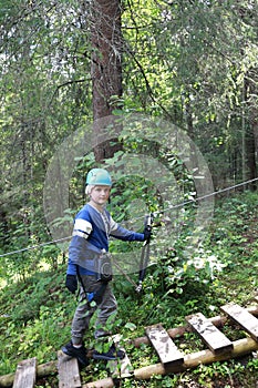 Kid with climbing equipment in summer park