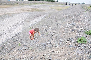 Kid climbing the hill in dried river bed in Middle Asia Kazakhstan