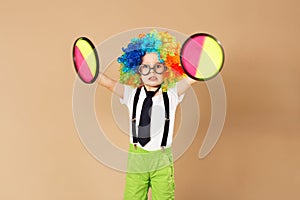 Kid in clown wig and eyeglasses playing catch ball game