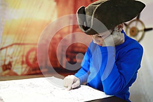 Kid in cocked hat examines map