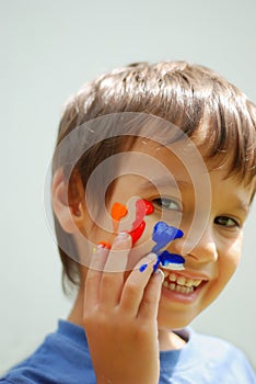 Kid with color on his fingers and face