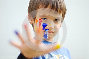 Kid with color on his fingers and face