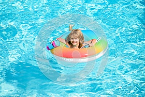 Kid with colorful floating ring. Child in swimming pool. Summer holiday. Kids water toys. Little boy swim. Child water