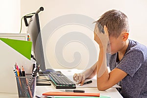 Kid with computer doing homework at home. Learning difficulties, online learning, education concept