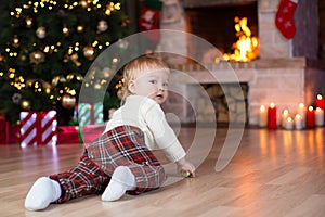 Kid crawling to gifts lying under Christmas tree